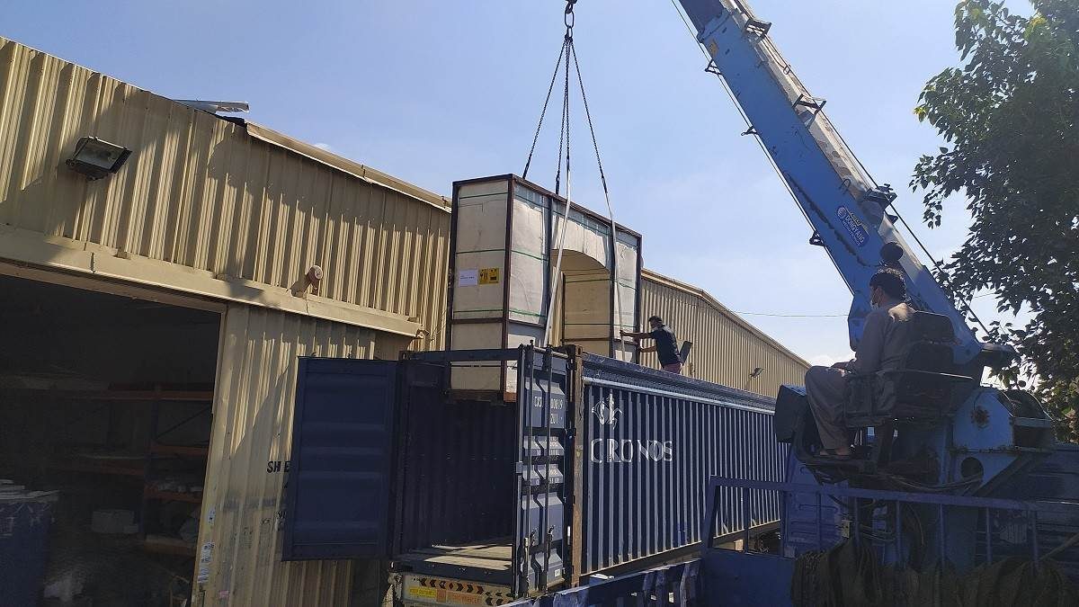 Custom Gate Aquarium: A 5-Metre Aquarium Built Around the Entrance 6 Crane lifting a large crate onto a truck during delivery logistics for a custom aquarium