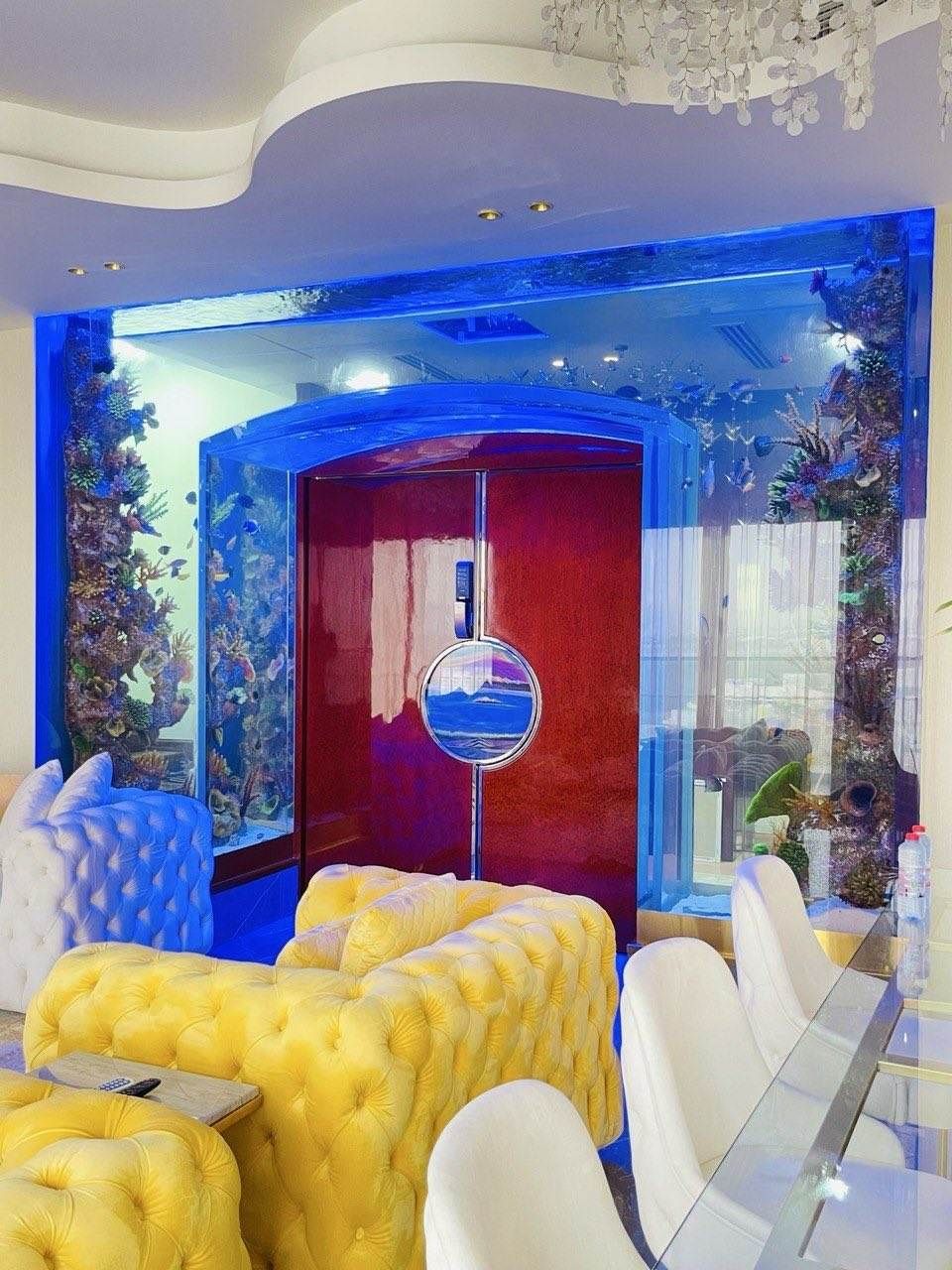Custom Gate Aquarium: A 5-Metre Aquarium Built Around the Entrance 5 Gate aquarium installed in a lounge with yellow tufted sofas and an arched entrance