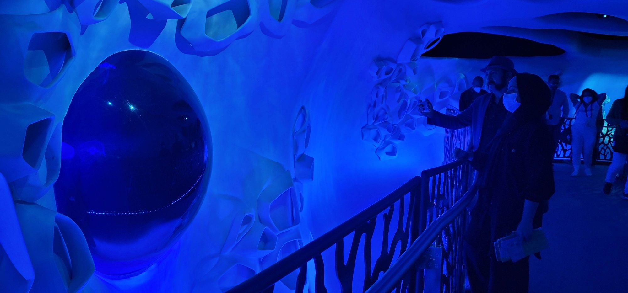 Expo 2020 Jellyfish Tank: A Custom Kreisel Display for the Terra Sustainability Pavilion 6 Visitors at the railing watching the jellyfish display tank at Expo 2020 Dubai