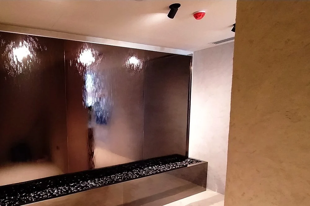 Commercial Water Features for Hotels, Malls and Developments in the UAE 1 Bronze mirror water wall with a pebble basin in a lobby