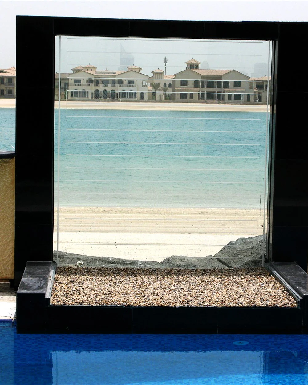 Infinity Pool Glass Wall: Design & Engineering Guide 1 Glass water wall at the edge of a Palm Jumeirah pool