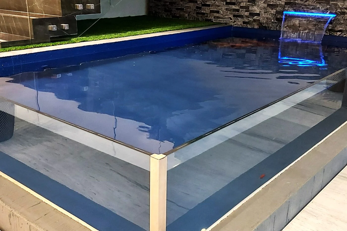 Indoor plunge pool with an acrylic viewing wall and water blade