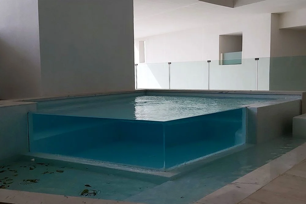 How Much Does a Modern Pool Cost in Dubai? (2026 Guide) 1 Plunge pool with a clear acrylic wall in a courtyard