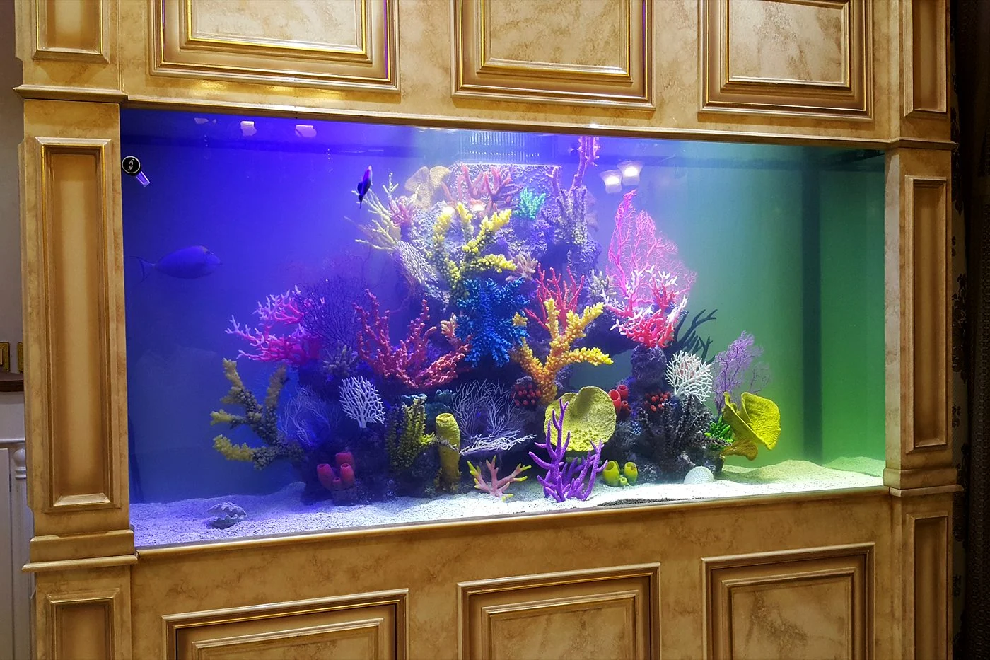 Reef aquarium set into an ornate cream panelled wall