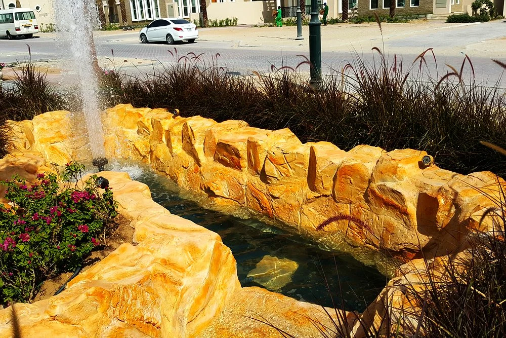 Water Feature Ideas for Dubai Villa Gardens 1 Rock channel with a fountain jet and flowers