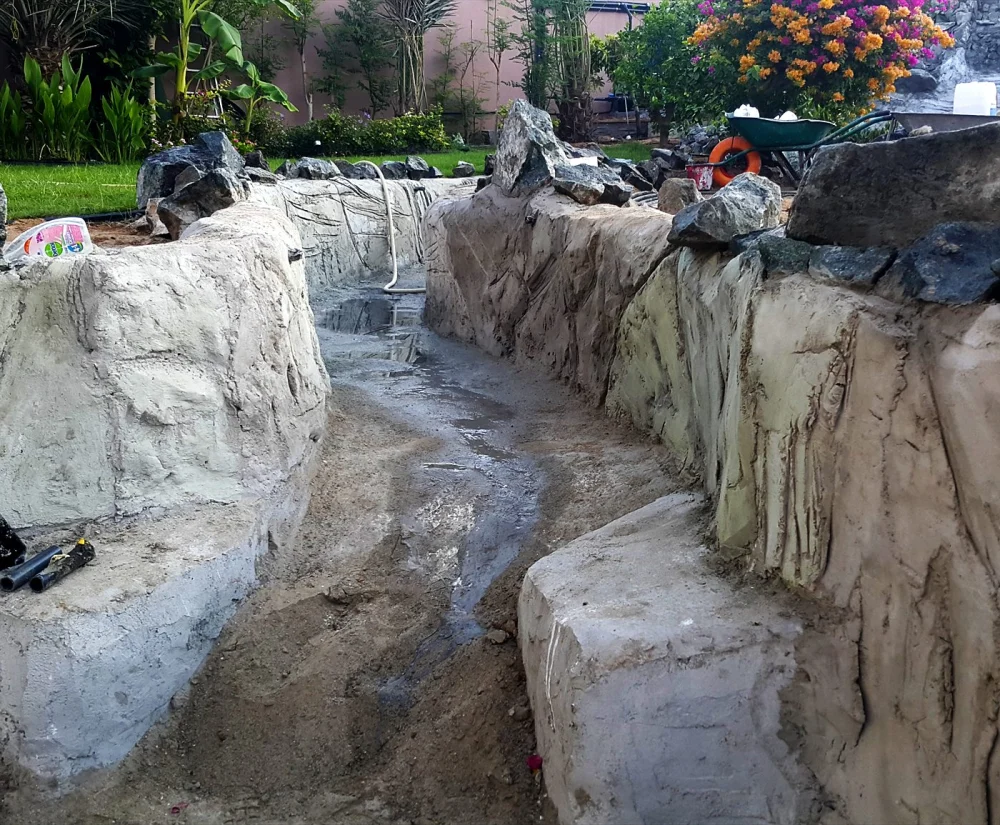 Concrete vs Liner Pond: Waterproofing for UAE Heat 1 Rockwork and channel under construction for a villa pond