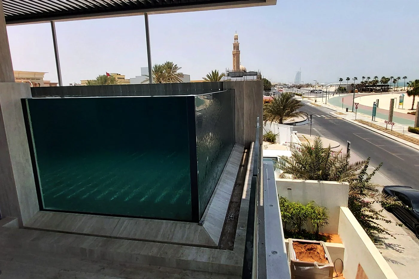 Rooftop pool with a clear acrylic wall above a Dubai street