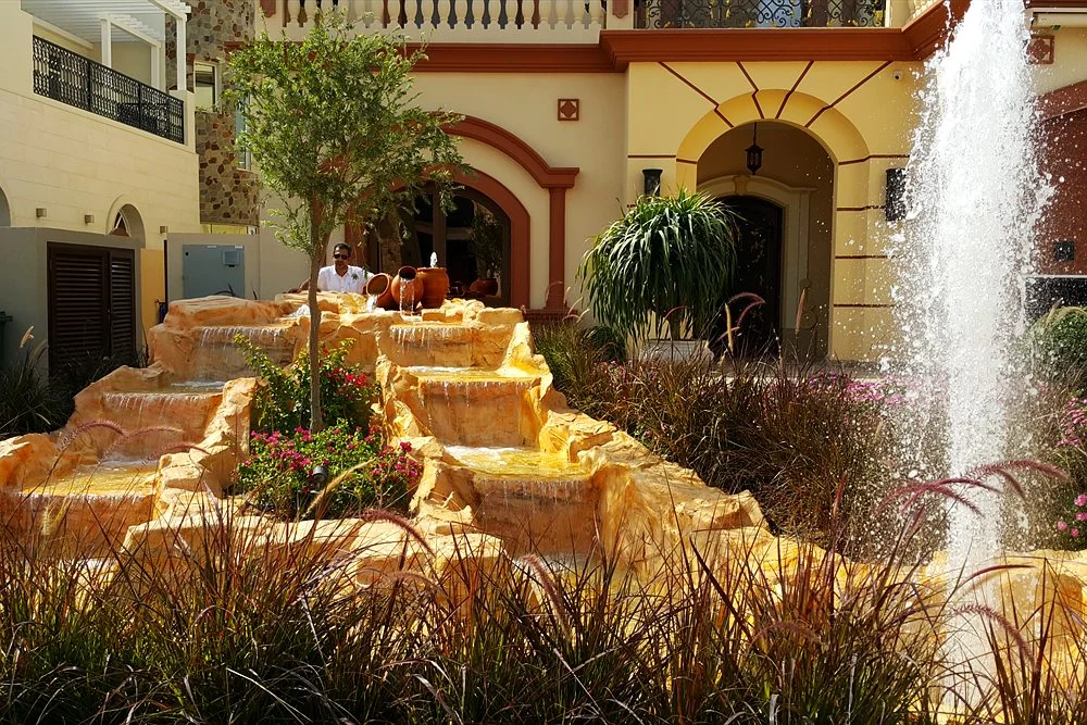 Outdoor Waterfall Design: Natural Rock, Artificial Rock and Spillways 1 Sandstone cascade fountain in front of a villa entrance