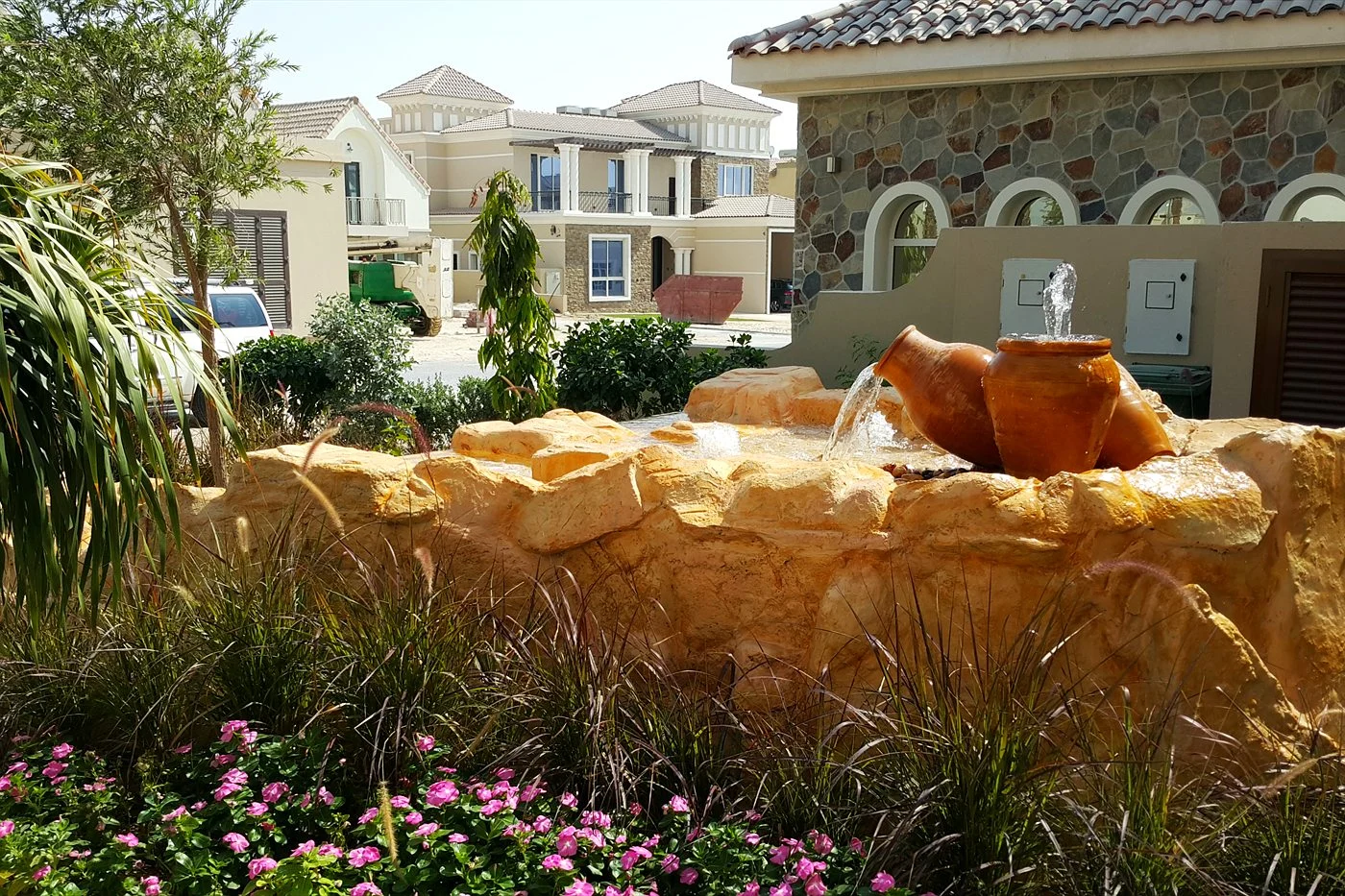 Sandstone-look water feature with plants in a villa garden
