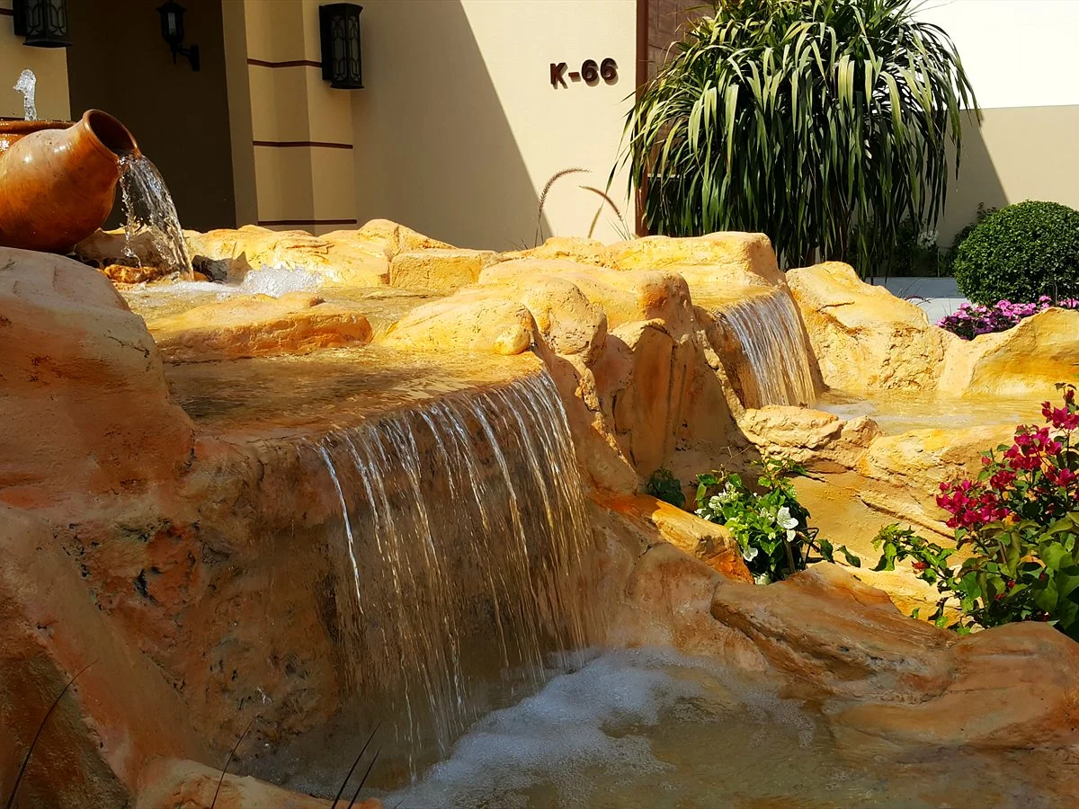 Sandstone-look waterfall cascading in a villa garden