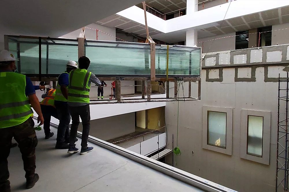 Aquarium Weight and Floor Load: Can Your Villa Take a Large Tank? 1 Team carrying an aquarium across a building atrium