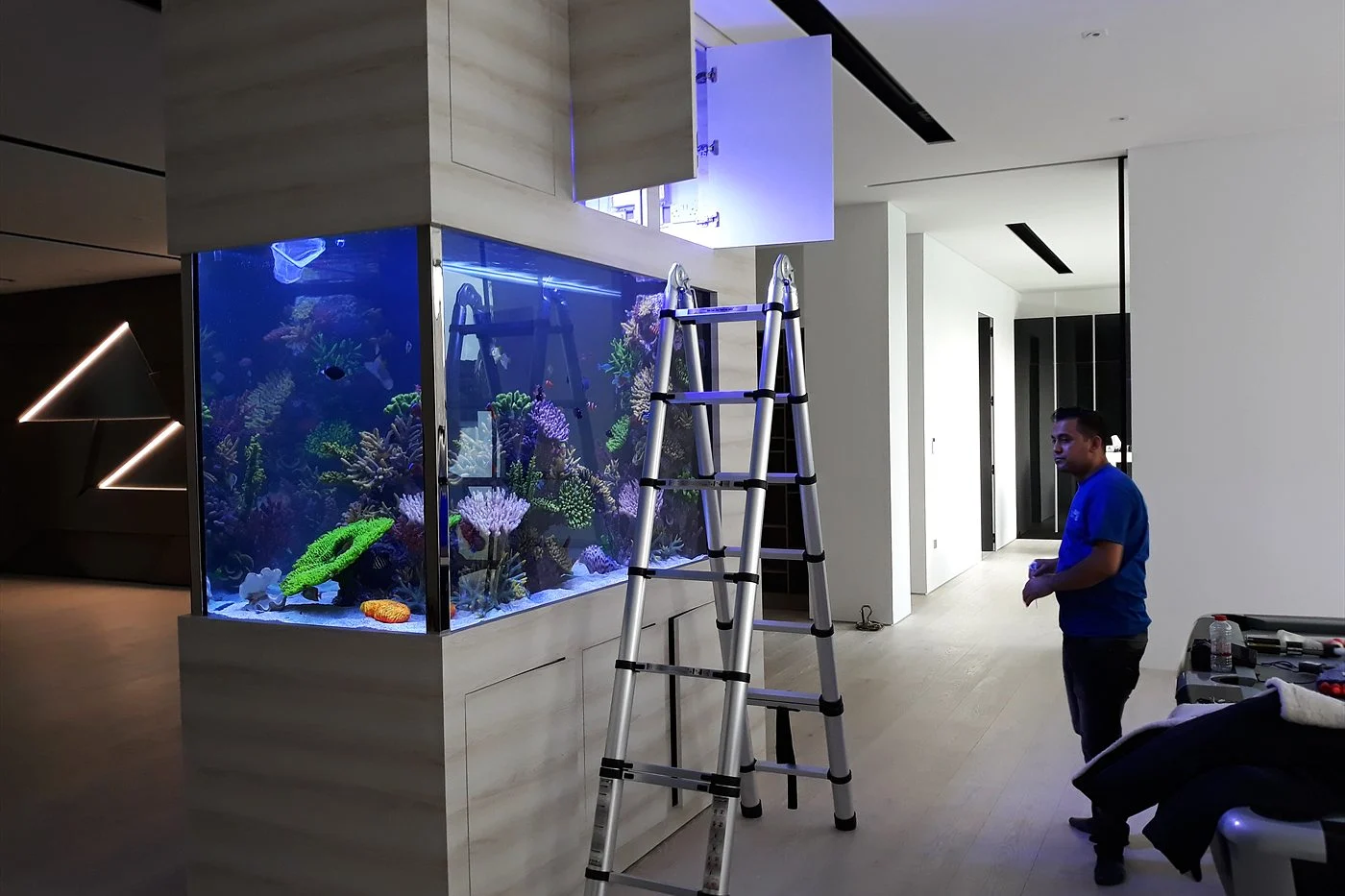 Technician completing a corner aquarium installation in a modern Dubai home