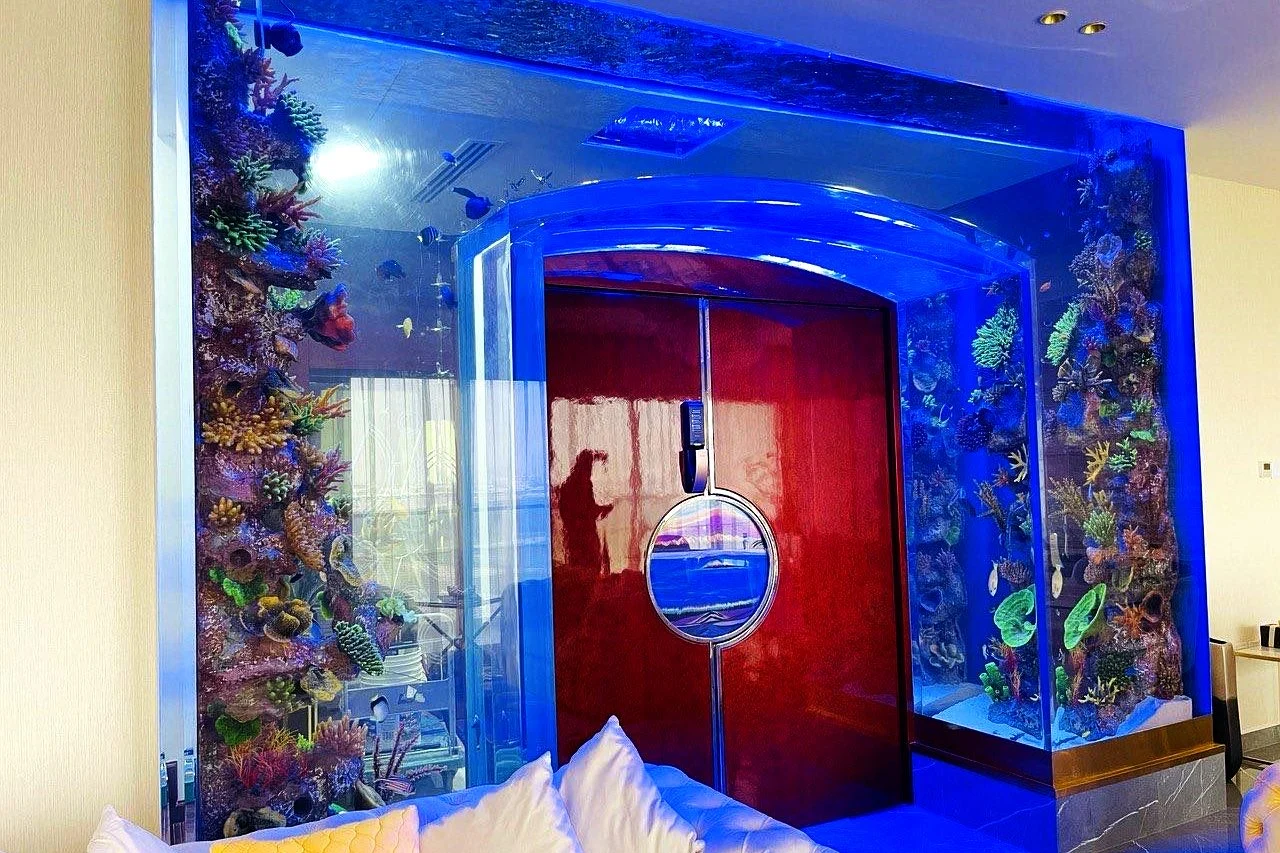 Walk-in aquarium frame around a red door in a villa